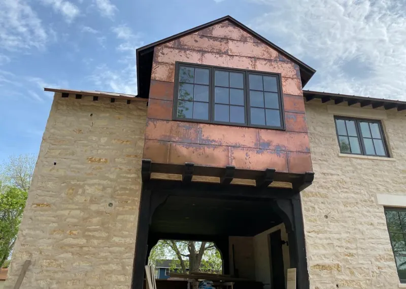 Copper metal panel facade on a stone building for Roof Repair in Valencia West